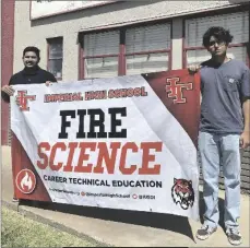  ?? PHOTO ELIZABETH MAYORAL CORPUS ?? Imperial High junior Alexandro Nieves Burgos (right) and his teacher, CTE fire instructor Daniel Martinez, hold up a banner for the school’s fire science program on Wednesday.