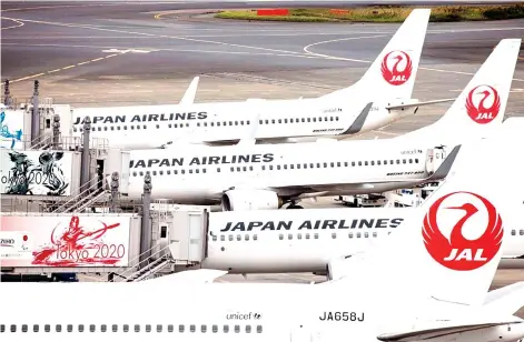  ?? — AFP photo ?? JAL revised down its net profit estimate to 25 billion yen from 45 billion yen, saying domestic business demand is recovering slowly and the effects of the government’s support for tourism have been limited.