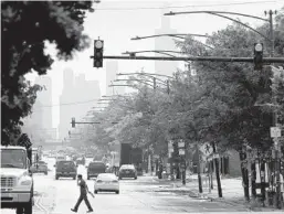  ?? ANTONIO PEREZ/CHICAGO TRIBUNE ?? The Chicago skyline looms over the homes and trees lining West Chicago Avenue on Wednesday.