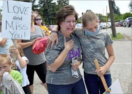  ?? Matt Freed/Post-Gazette ?? Karen Suchy, of Baldwin Borough, is supported by her niece, Reese Temme, as she catches sight of her mother, Betty Milinski, for the first time in months on Friday at Norbert Personal Care Home in Overbrook.