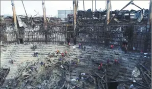  ?? RUSSIAN EMERGENCIE­S MINISTRY VIA REUTERS ?? Workers remove debris inside the Crocus City Hall following a deadly attack on the concert venue in Moscow in this image taken from a video released on Tuesday.