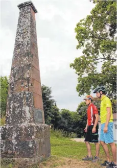  ?? FOTO: MICHAEL HOCHHEUSER ?? Mehr als fünf Meter hoch ist der Obelisk auf dem Dreifaltig­keitsberg, der einst als Gradmessun­gspfeiler diente. Dominik und Fabian Albrecht ( rechts) schauen sich den steinernen Zeitzeugen bei einer Radtour an.