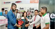  ??  ?? L.R.P. Dossa handing over the first sale of the new showroom to Gayan Fernando as Sales and Marketing General Manager Ruwan Singhabahu looks on