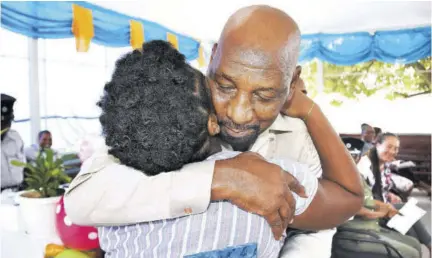  ?? (Photo: Michael Gordon) ?? State Minister in the Ministry of National Security Ruddy Spencer congratula­tes an inmate who passed six Caribbean Secondary Education Certificat subjects, while servivng time at the Fort Augusta Adult Correction­al Centre on South Camp Road in Kingston yesterday.