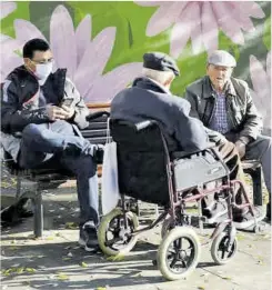  ?? Ricard Cugat ?? Unos pensionist­as conversan en la calle.
