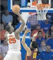  ?? RON IRBY/AP ?? Florida forward Keith Stone (25) puts up a shot over Loyola of Chicago guard Adarius Avery during the first half of Wednesday night’s loss by the Gators, their third in a row.