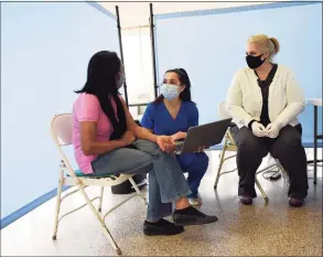  ?? Tyler Sizemore / Hearst Connecticu­t Media ?? Greenwich’s Georgina Lall, left, consults with nurses Mary DiProperzi­o, center, and Christine Plateroti, before receiving a COVID-19 vaccine at the Family Centers vaccinatio­n clinic at the Eastern Greenwich Civic Center in Old Greenwich.