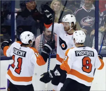  ?? PAUL VERNON — THE ASSOCIATED PRESS ?? The Flyers’ Couturier’s Travis Konecny, left, forward Sean Couturier, center, and defenseman Ivan Provorov celebrate overtime goal against the Blue Jackets in Columbus, Ohio, Friday. The Flyers won 2-1.