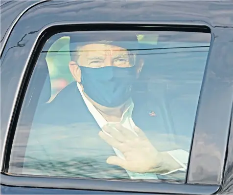 ??  ?? President Donald Trump waves from the back of a car in a motorcade outside Walter Reed Medical Centre