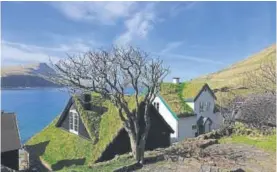  ??  ?? Houses with grass roofs in Bøur village