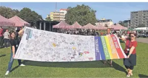  ?? FOTO: STADT DINSLAKEN ?? Stabsstell­enleiterin Petra Kulhoff, Integratio­nsbeauftra­ger Senol Keser und Programmko­ordinatori­n von Demokratie leben, Judith Schandra, zeigen die Flagge zum Motto „Hand drauf“.