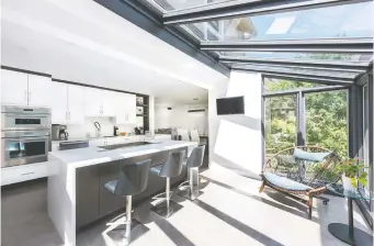  ??  ?? A kitchen with a bright sunroom maximizes backyard views in this Amsted Design-Build renovation.