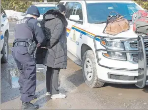  ?? CP PHOTO ?? An asylum claimant claiming to be from Turkey is handcuffed after crossing the border into Canada from the United States Thursday near Hemmingfor­d, Que. A growing number of people have been walking across the border into Canada to claim refugee status,...