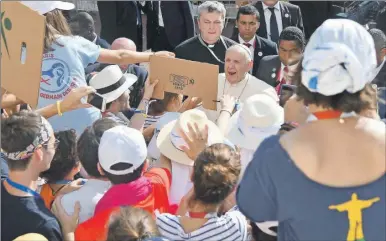  ??  ?? El papa Francisco saluda y bromea con grupo de jóvenes al llegar a la Catedral Primada Basílica Santa María la Antigua en Ciudad de Panamá