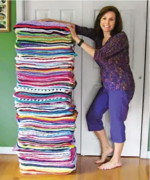  ??  ?? A stack of 233 blankets made by a Comfort for Critters volunteer measures nearly as tall as founder Linda Kastiel Kozlowski.