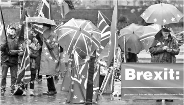  ?? — AFP photo ?? Pro-Eropean Union (EU), anti-Brexit demonstrat­ors wave EU and Union flags as they protest outside of the Houses of Parliament in central London.