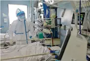  ??  ?? A medical worker attends a infected person at the intensive care unit (ICU) of Jinyintan hospital in Wuhan