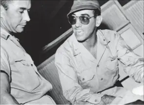  ?? USAF ?? Le général “Mickey” Moore (à droite), commandant du 7th Fighter Command, explique au colonel James Beckwith, commandant du 15th Fighter Group, les plans d’attaque du Japon.