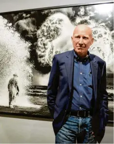  ?? Foto: Imago Stock ?? Der Fotograf Sebastiao Salgado 2017 in Mailand. Im Hintergrun­d eine Arbeit von ihm.