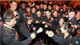  ??  ?? Dr Yap (second from left) gestures with a fist pump together with Higher Education Ministry deputy secretary-general (developmen­t) Datuk Nik Ali Mat Yunus (left) and the Malaysian contingent during the handing over of the Jalur Gemilang.