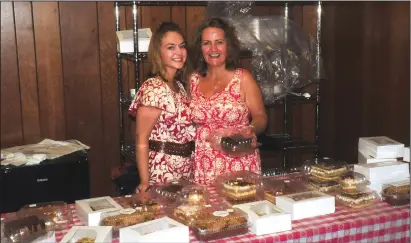  ??  ?? Kinga Walkosz, left, and her mom, Anna Walkosz, are busy making sales at the bake table with cakes and pastries made and donated by fellow parishione­rs during the annual Polish Picnic at St. Stanislaus Catholic Church inside the parish center Saturday.