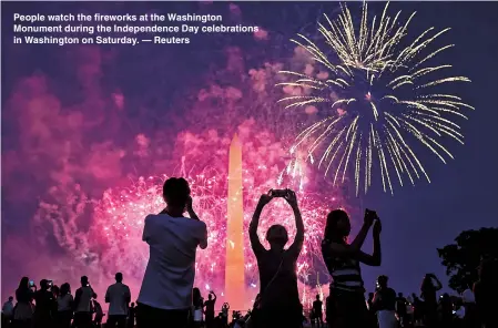  ??  ?? People watch the fireworks at the Washington Monument during the Independen­ce Day celebratio­ns in Washington on Saturday. — Reuters