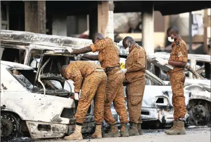  ?? PICTURES: AP ?? Soldiers examine burnt-out cars outside the Splendid Hotel in Ouagadougo­u, Burkina Faso’s captial, after it was attacked by al-Qaeda-linked extremists. Islamic extremism is on the rise in the West African country.