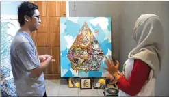  ?? HANUNG HAMBARA/JAWA POS ?? Jawa Pos SISIPKAN BUDAYA JAWA: Agung Prabowo (kiri) menjelaska­n lukisan dengan teknik pop art super flat yang berjudul ”Sisi Lain” di Pawitra Art Space, Porong, kemarin.
