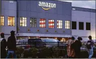  ?? Associated Press file photo ?? People arrive for work at the Amazon distributi­on center in the Staten Island borough of New York in October.