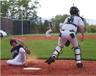  ?? STAFF PHOTOS BY ANGELA LEWIS FOSTER ?? Chattanoog­a Christian School’s Chase McBryar slides safely across the plate as Notre Dame catcher Lane Cannon waits for the throw Tuesday at Notre Dame High School. CSS won 9-2.