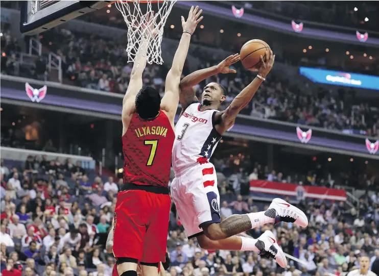  ?? — GETTY IMAGES ?? The Wizards’ Bradley Beal, challengin­g the Atlanta Hawks’ Ersan Ilyasova at the net, scored 27 points in Washington’s 103-99 Game 5 victory at Verizon Center.