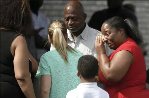  ?? SHELLEY MAYS — THE TENNESSEAN ?? Ieshea White cries tears of joy after being reunited with her uncle Roger Bracey, center, who was at Burnette Chapel Church of Christ when shots were fired Sunday in Antioch, Tenn. They were reunited at another nearby church.