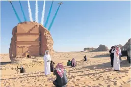  ??  ?? DESERT DAREDEVILS: Visitors watch an aerial flying display over Mada’in Saleh, a Unesco World Heritage Site, in Saudi Arabia.