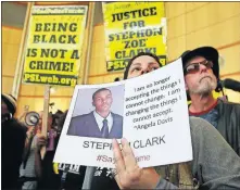  ?? [AP FILE PHOTO] ?? Anita Ross holds a photo of 22-year-old Stephon Clark, an unarmed black vandalism suspect who was fatally shot by police, as she and other protesters block the entrance to Sacramento City Hall last March in Sacramento, Calif. California's first-in-the-nation attempt to track racial profiling complaints against police produced numbers so unrealisti­cally small that the board overseeing the tally wants department­s to make changes to encourage more people to come forward.