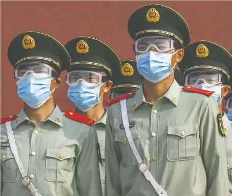  ?? KEVIN FRAYER/GETTY IMAGES ?? Chinese paramilita­ry police guard the entrance to the Forbidden City as it reopened to limited visitors Saturday in Beijing. Canada must stand up to China, which is a bully that thumbs its nose at global norms, laws and institutio­ns, writes Diane Francis.