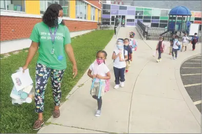  ?? Ned Gerard / Hearst Connecticu­t Media ?? Teacher Sharaya Pinkney leads her class of kindergart­ners into Bridgeport’s Roosevelt School. How teachers interact with students is one of several measuremen­ts districts use to evaluate how well they do their jobs.