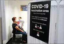  ?? MARCIO JOSE SANCHEZ / AP ?? In this March 1 photo, a patient receives a shot of the Moderna COVID-19 vaccine next to a guidelines sign at a CVS Pharmacy branch in Los Angeles.