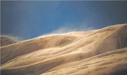  ?? Joe Amon, The Denver Post ?? Strong winds and light rain blow sand up and over the dunes at Great Sand Dunes National Park on April 31.