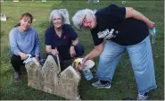  ?? COURTESY JOETTE KUNSE ?? Lindsay Lawless, Charlotte Cooper and Debi Parrett clean gravestone­s at the Sashabaw Plains Cemetery in Independen­ce Township.