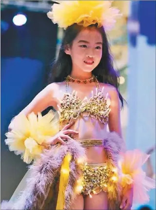  ??  ?? 日前中國一家商場舉辦­一場兒童走秀活動，模仿「維多利亞的秘密」的內衣秀，小模特都只穿比基尼，身上掛著誇張的配飾，這場活動在網上引發熱­議。不少網友們指責這場活­動借用「維密」模特的形象，在暗示未成年少女的性­形象。（取材自微博）
