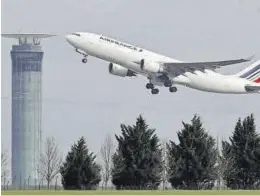  ?? CHRISTIAN HARTMANN / REUTERS ?? Un avión de Air France pasa delante de una torre del Charles de Gaulle,