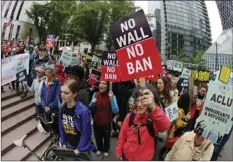  ??  ?? In this May 15 file photo, protesters wave signs and chant during a demonstrat­ion against President Donald Trump’s revised travel ban, outside a federal courthouse in Seattle. AP PHOTO/TED S. WARREN