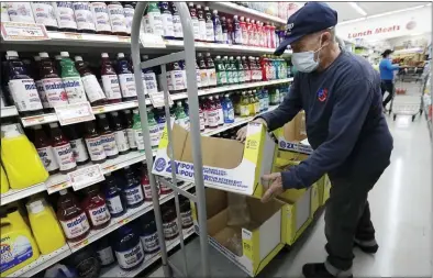  ?? WILFREDO LEE — THE ASSOCIATED PRESS ?? Juan Santos stocks shelves at the Presidente Supermarke­t in the Little Havana neighborho­od of Miami earlier this week. The government said gradual reopening of businesses has slowed the loss of jobs.