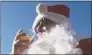  ?? John Minchillo / Associated Press ?? A man dressed as Santa Claus drinks a beer as he during SantaCon in New York City in 2014.