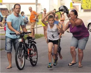  ?? Fotos: Reinhold Radloff ?? Wieder zurück steht das Hilfsperso­nal schon bereit, nimmt Rad und Helm ab und schickt den jungen Athleten auf die abschließe­nde Laufstreck­e.