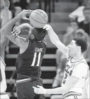  ??  ?? GOING FOR the ball but clipping Gary Clark’s head, Lonzo Ball commits a foul as he tries to block a shot.