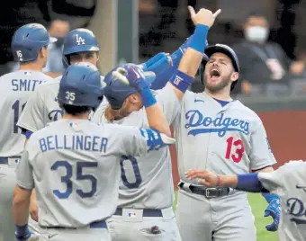  ?? Curtis Compton, Atlanta Journal- Constituti­on ?? The Dodgers’ Max Muncy celebrates his grand slam with his teammates during the first inning against the Braves in Game 3 of NLCS on Wednesday in Arlington, Texas.