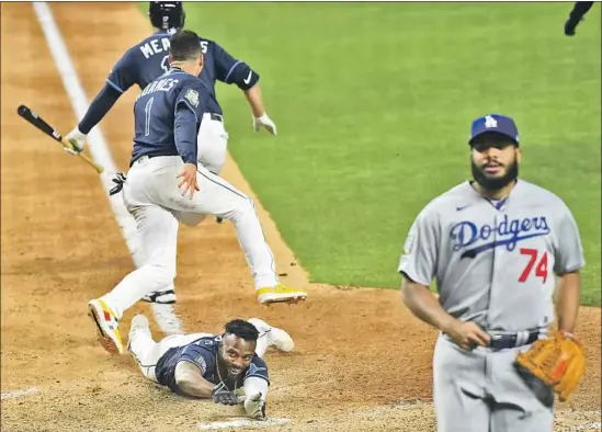  ?? RANDY AROZARENA Photog raphs by Wally Skalij Los Angeles Times ?? of the Rays scores the winning run, thanks to a hit and an error, as teammates celebrate in front of losing Dodgers pitcher Kenley Jansen.