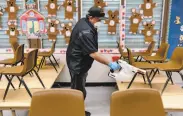  ?? Michael Short / Special to The Chronicle ?? Hoyt McCracken uses an electrosta­tic sprayer to disinfect a Fremont classroom in March.