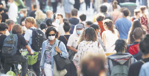  ??  ?? People wearing protective face masks walk in a busy street, Paris, France, Sept. 18, 2020.